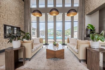 A living room with a large window and a view of the city.